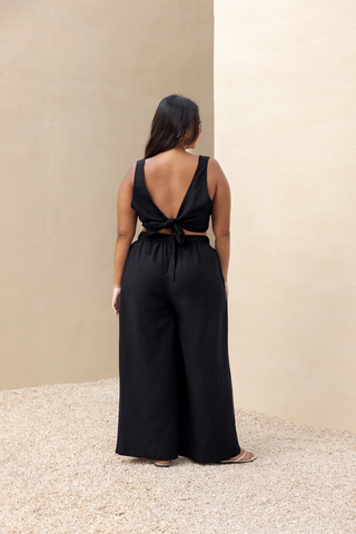 Rawbought Terra Wide Leg Trousers with high waist and flowing silhouette, featuring zipper, elasticated back, and pockets, crafted from soft linen blend, available in sizes XS to XXXL in Coal and Sand.