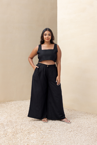 Rawbought Terra Wide Leg Trousers with high waist and flowing silhouette, featuring zipper, elasticated back, and pockets, crafted from soft linen blend, available in sizes XS to XXXL in Coal and Sand.