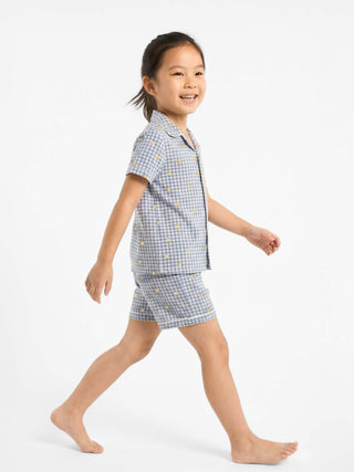 Child wearing Rawbought's SundayCitrus pyjamas in blue gingham and lemon print
