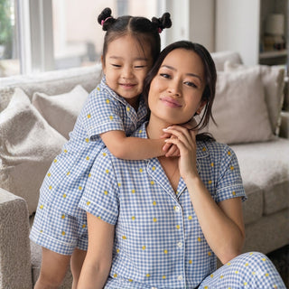 Woman and child in matching blue checkered pyjamas by rawbought at home