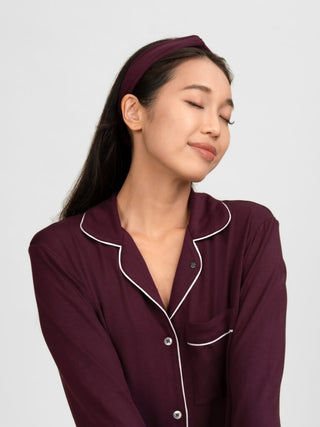 Woman wearing rawbought burgundy pyjama set with white piping with matching modal head band