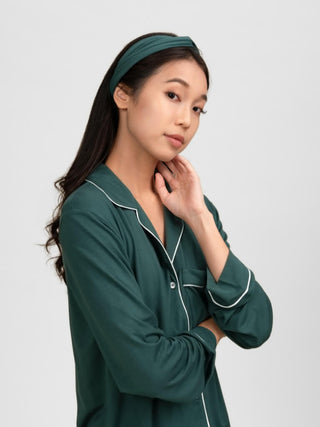 Woman wearing a green pajama set with white piping