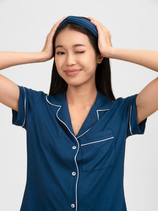 Woman wearing rawbought blue pyjama top with white trim with modal head band