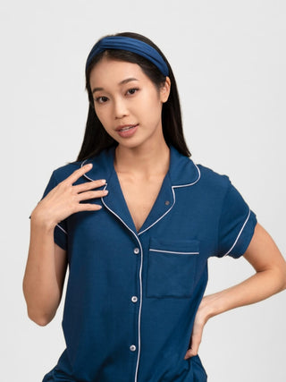 Woman wearing a blue pyjama set with white piping