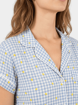 Woman wearing Rawbought's  blue and white gingham pajama top with fresh yellow lemon print